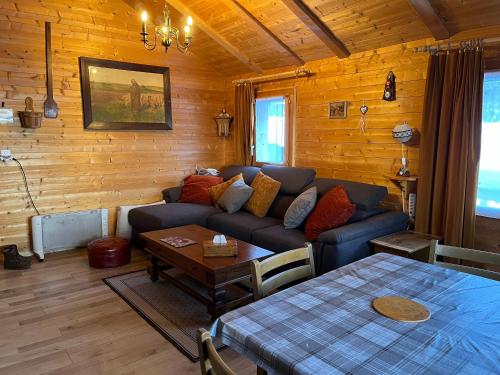 uma sala de estar com um sofá e uma mesa em Le Mazot em Troistorrents