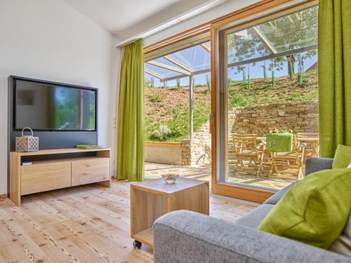 a living room with a tv and a sliding glass door at WEINVIERTLER KELLERSTÖCKL Weingut Hindler in Schrattenthal