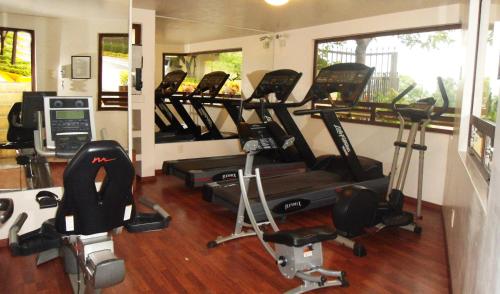 a gym with several treadmills and elliptical machines at Hotel Fortin Plaza in Oaxaca City