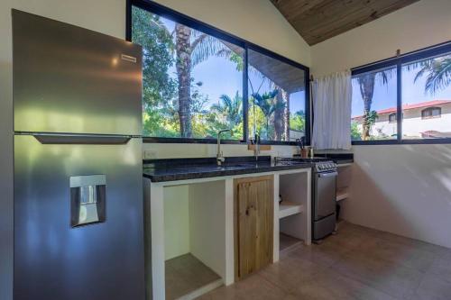 a kitchen with a sink and a large window at The Surf Journey Casita in Uvita