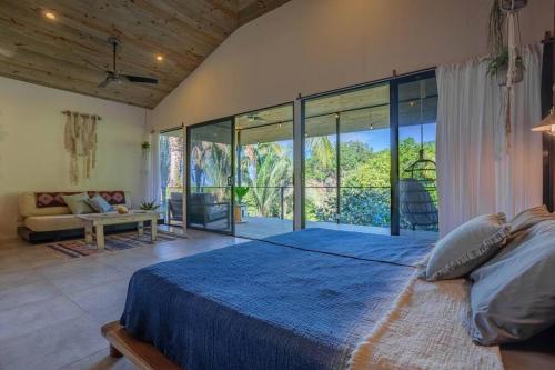 a bedroom with a large bed and a large window at The Surf Journey Casita in Uvita