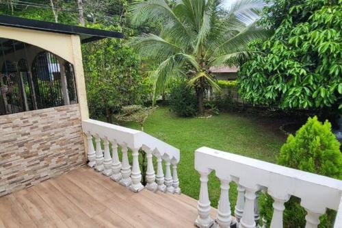ein Haus mit einem weißen Zaun und einem Hof in der Unterkunft Casa Congo in Golfito