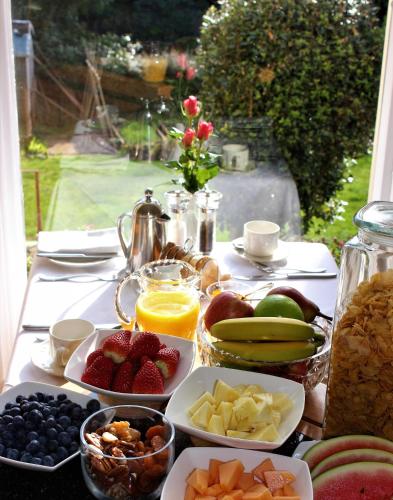 a table topped with plates of fruit and other food at Trafalgar House in Torquay