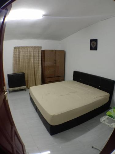 ein Schlafzimmer mit einem Bett in einem Zimmer in der Unterkunft Sobey Laris Homestay UMK in Bachok