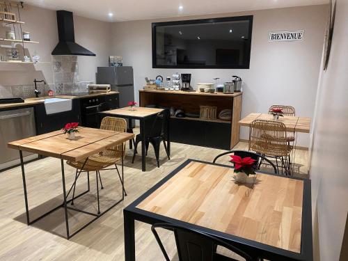 a room with tables and chairs in a kitchen at Ferme "les Flaquettes" in Guînes