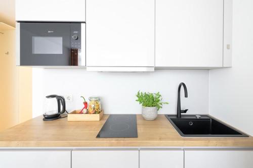 a kitchen counter with a sink and a microwave at Huber Living Basic 102 in Germering