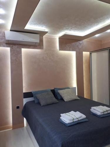 a bedroom with a blue bed with towels on it at Obzor Tatyana Apartaments Nemo in Obzor