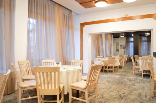 a dining room with tables and chairs and windows at Rila Hotel Sofia in Sofia