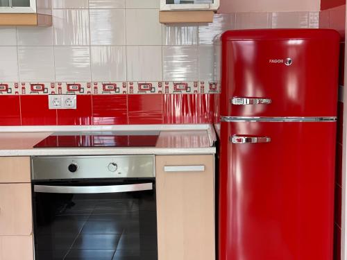 a red refrigerator in a kitchen next to a stove at Cotillo Lagoons Apartment in El Cotillo