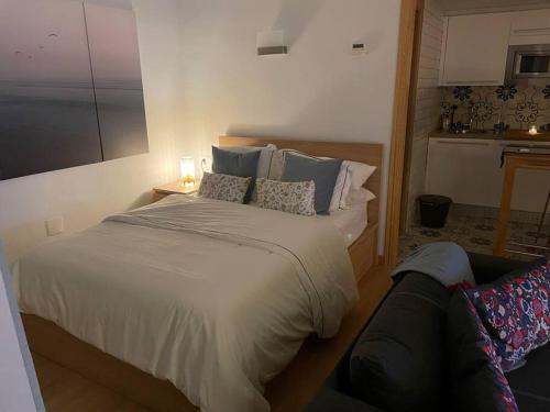 a bedroom with a bed with pillows and a couch at Cozy Renovated Studio located in centre of Benalmadena and Puerto Marina in Benalmádena