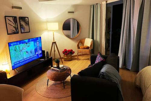 a living room with a couch and a flat screen tv at Cozy Renovated Studio located in centre of Benalmadena and Puerto Marina in Benalmádena