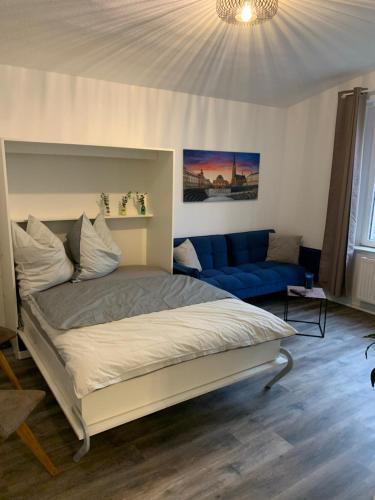 ein Schlafzimmer mit einem Bett und einem blauen Sofa in der Unterkunft 40 qm Appartment Parkplatz, Balkon,Netflix, Prime in Chemnitz