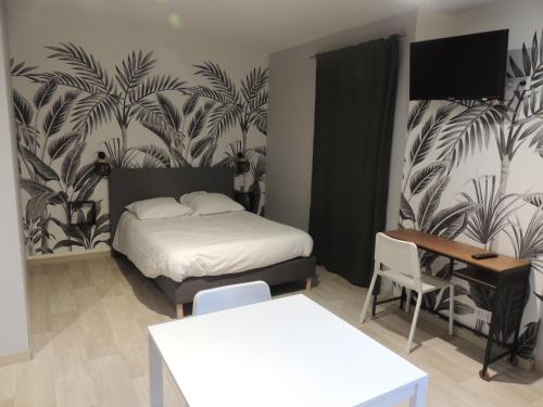 a bedroom with a bed and a table and a desk at O'ZINC in Viviez