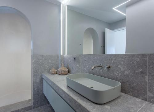 W łazience znajduje się biała umywalka i lustro. w obiekcie Super Luxury Mykonos Villa - Villa Saorsa - 5 Bedroom - Infinity Pool - Panoramic Sea Sunset Views w mieście Dexamenes