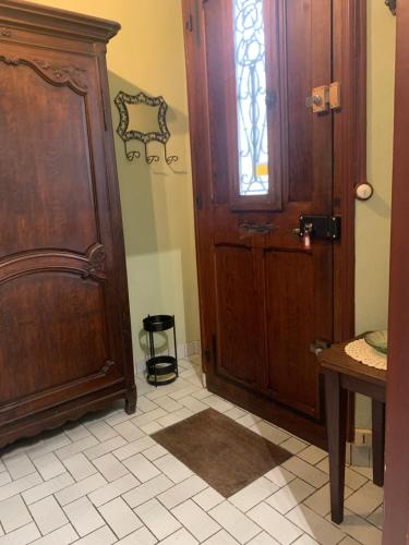 Cette chambre dispose d'une porte en bois et de carrelage. dans l'établissement Appartement proche basilique Saint Rémi, à Reims