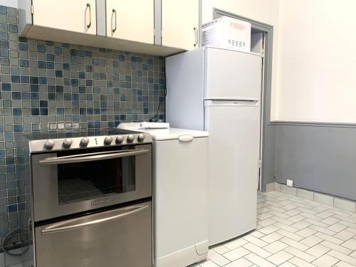 une cuisine avec une cuisinière et un réfrigérateur dans l'établissement Appartement proche basilique Saint Rémi, à Reims