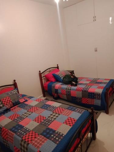 - deux lits assis l'un à côté de l'autre dans une pièce dans l'établissement Bel app, à Agadir