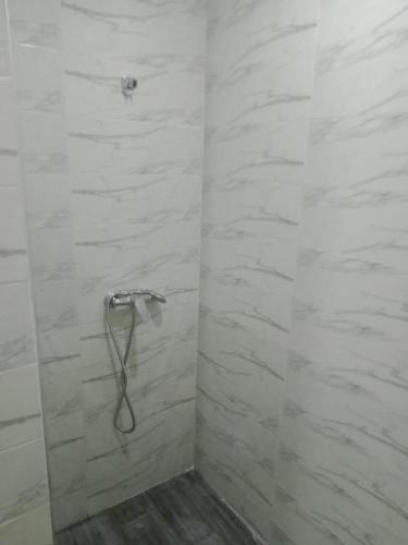 La salle de bains blanche est pourvue d'une douche et d'un tuyau. dans l'établissement Bel app, à Agadir