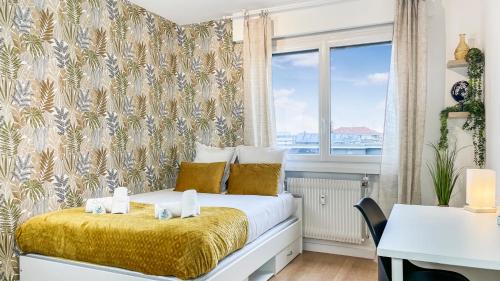 1 dormitorio con cama, escritorio y ventana en HOMEY LA COLOC MUGI - Colocation haut de gamme - Chambres privées - Balcon - Wifi et Netflix - Proche transports commun, en Annemasse