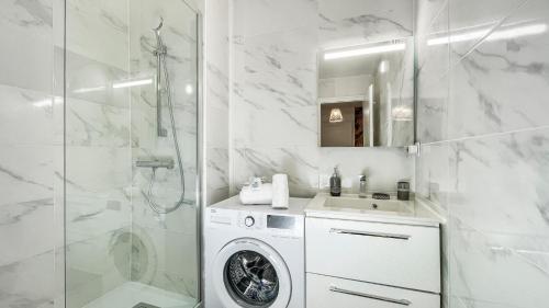 bagno bianco con lavatrice e doccia di HOMEY LA COLOC MUGI - Colocation haut de gamme - Chambres privées - Balcon - Wifi et Netflix - Proche transports commun ad Annemasse