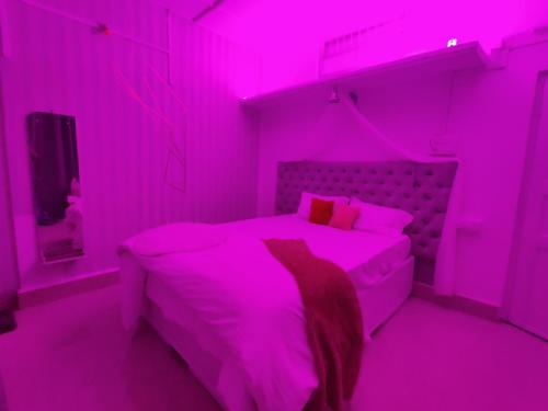 a pink bedroom with a bed and a tv at Gianna Homestay in Jorhāt