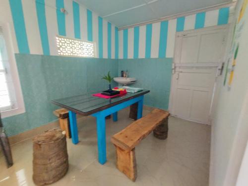 a bathroom with a blue table and a sink and a bench at Gianna Homestay in Jorhāt