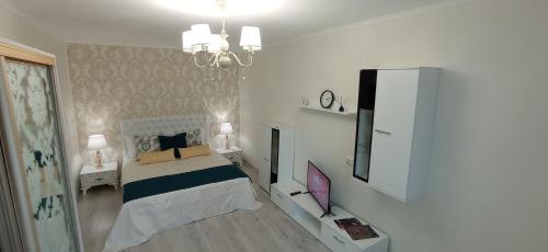 a bedroom with a bed and a television in it at Park Apartments in Dnipro