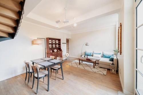salon ze stołem, krzesłami i kanapą w obiekcie Maison des Pilastres au cœur d'Auxerre w mieście Auxerre