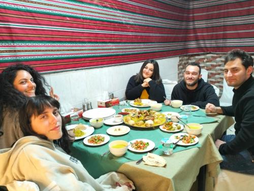een groep mensen die rond een tafel eten bij ZRIZIRA INN in Wadi Musa