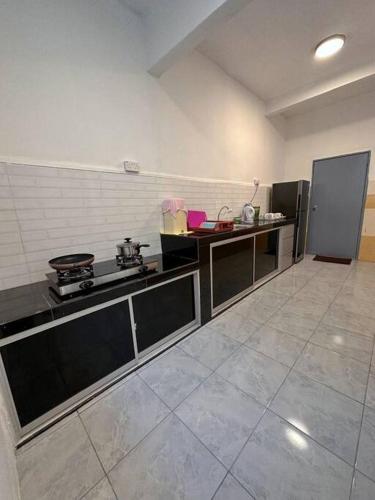 a kitchen with a stove and a refrigerator at Lovely & Cozy Apt In Nature City in Sandakan