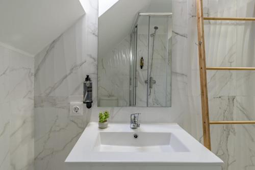 a white bathroom with a sink and a mirror at Good Vibes Apartment in Setúbal