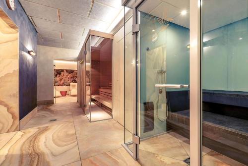 a bathroom with a shower and a glass wall at PLAZA INN Regensburg in Regensburg