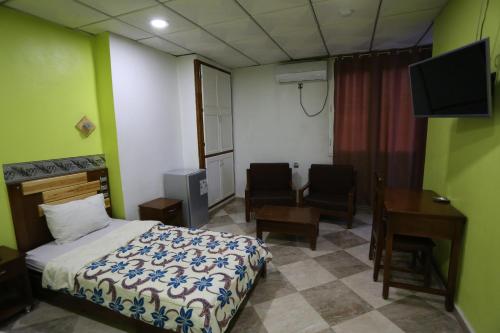 巴特纳的住宿－hotel brahimi batna，配有一张床、一张桌子和一张桌子的酒店客房