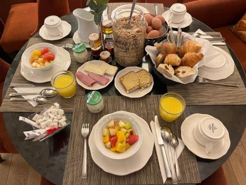 a table with breakfast foods and drinks on it at Les Tournelles in Paris