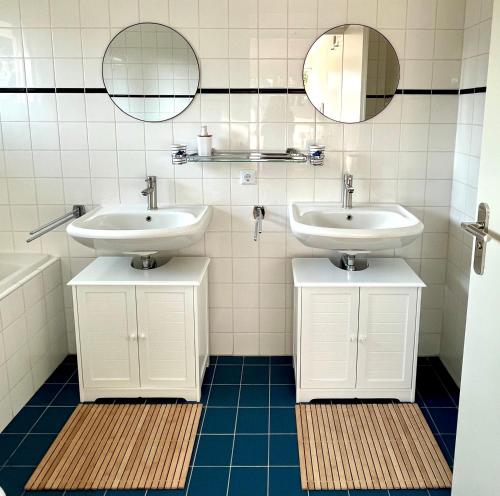 een badkamer met 2 wastafels en 2 spiegels bij Villa Sudersee in Workum