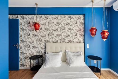 a bedroom with a bed with blue walls and red lamps at Wonder Blue in Setúbal
