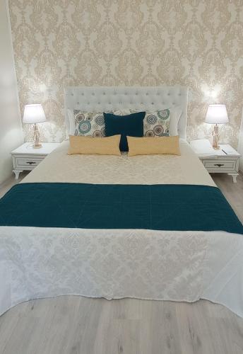 ein Schlafzimmer mit einem großen Bett mit zwei Lampen in der Unterkunft Park Apartment's Світло є завжди in Dnipro