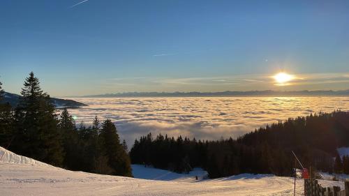 a view of the sun rising above a sea of clouds at Au Doubs Village in Métabief