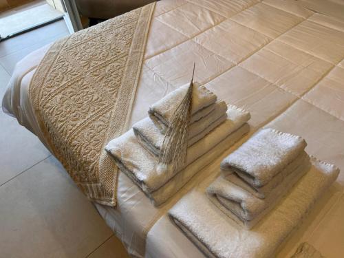 a pile of towels sitting on top of a bed at Welcome Cagliari in Cagliari