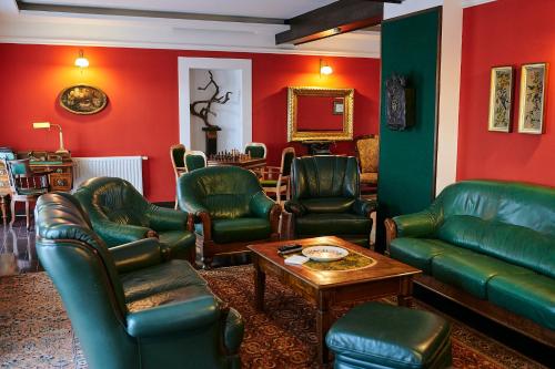 a living room with green leather furniture and red walls at Saciova Hills in Saciova