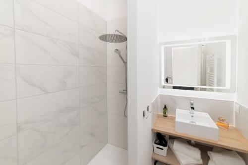 een witte badkamer met een wastafel en een douche bij Le Chardonnay - Locationtournus in Tournus