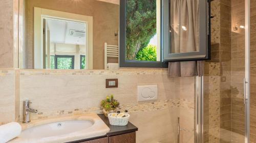 y baño con bañera, lavabo y espejo. en Al Solatio Villa in Collina con Piscina en Pontassieve