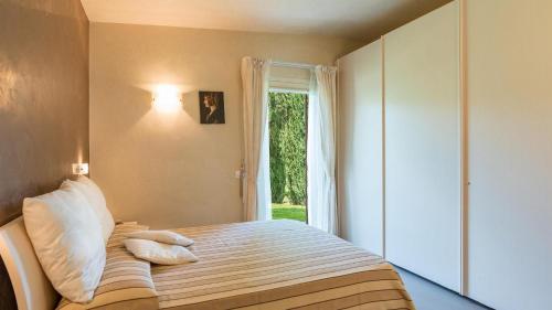 1 dormitorio con cama con almohadas y ventana en Al Solatio Villa in Collina con Piscina, en Pontassieve