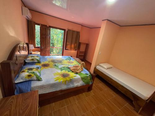 a bedroom with a bed with flowers on it at Ceiba lodge in Drake