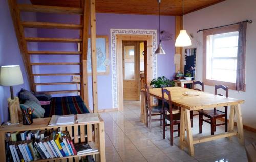 a living room with a wooden table and a book shelf at A Barraka: rent your room in Flores! in Lajes das Flores