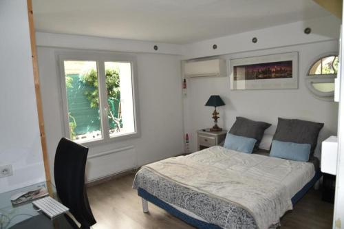 sypialnia z łóżkiem i oknem w obiekcie Rez de chaussée de Villa Marseille 9ème w Marsylii