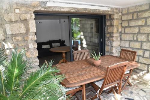 une table et des chaises en bois sur une terrasse dans l'établissement Rez de chaussée de Villa Marseille 9ème, à Marseille