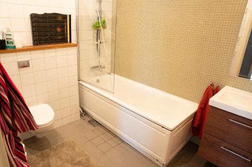 y baño con bañera, aseo y lavamanos. en Privatsvit, havsnära och centralt, en Malmö