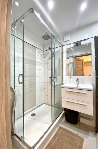 a bathroom with a shower and a sink at Apartament Słoneczny Ustka in Ustka