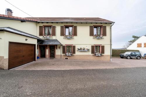 a house with a garage and a car parked at Maison accueillante à Dabo avec jardin clos in Dabo